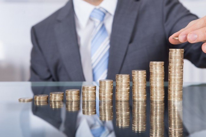 Businessperson With Stack Of Coins increase income
