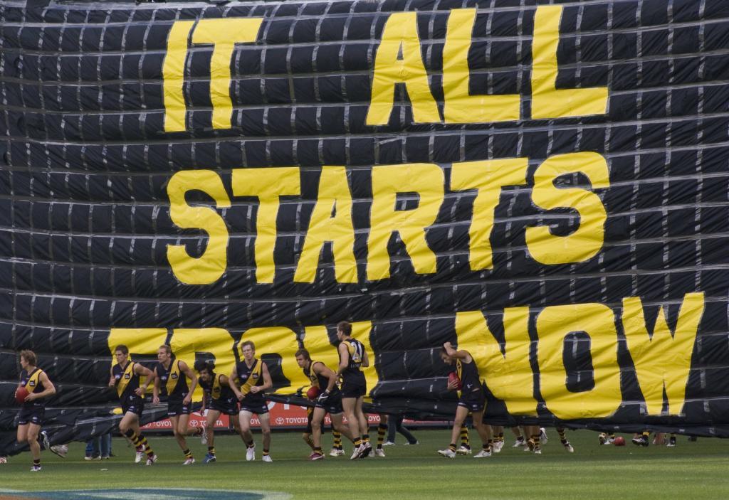 AFL team Tigers run through banner