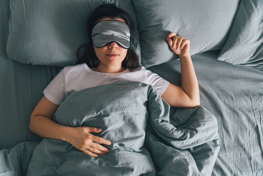 woman sleep in eye patch in grey bed. copy space