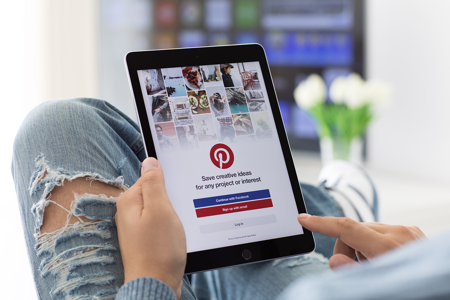 Alushta Russia - June 8 2017: Man holding iPad Pro Space Gray with social Internet service Pinterest on the screen. iPad Pro was created and developed by the Apple inc.