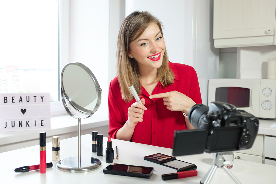 Professional beauty blogger showing mascara, eyeliner, eyelash cosmetics to video camera