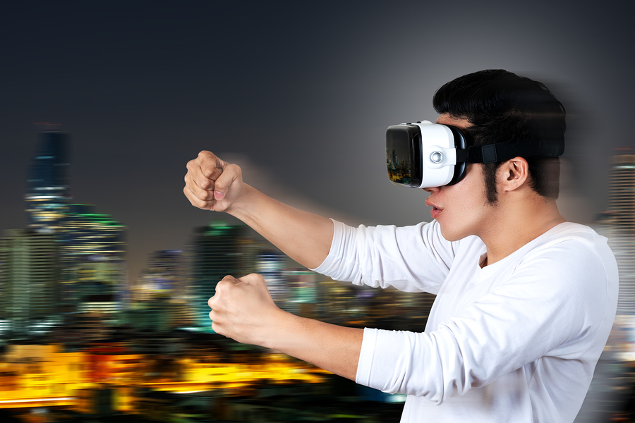 Young asian man in casual white outfit holding or wearing VR glasses goggles playing car racing video game, shocked and amazed on motion city background. Virtual reality of gamer experience concept.