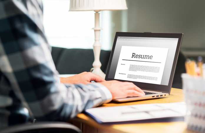 Man Writing Resume And Cv In Home Office With Laptop. Applicant The value in signing up for resume services
