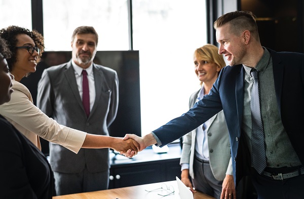 Two people shaking hands in welcoming business meeting