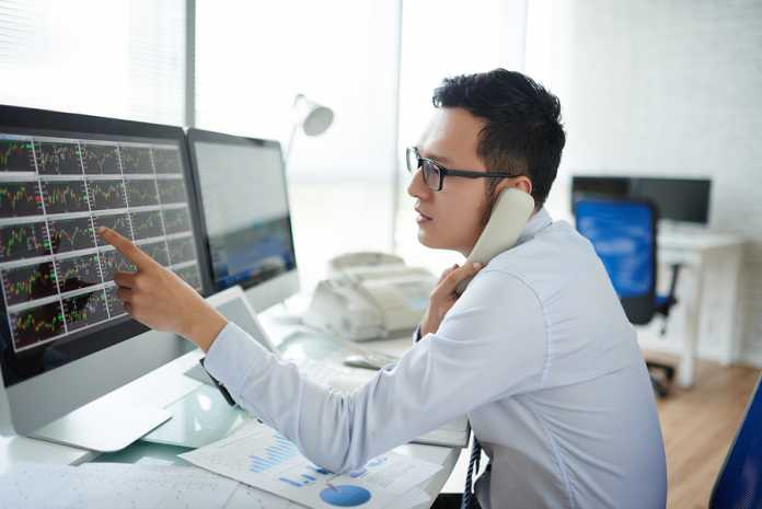 Young Vietnamese Stock Broker Discussing Stock Exchange Data On How to become a successful stock broker in Australia