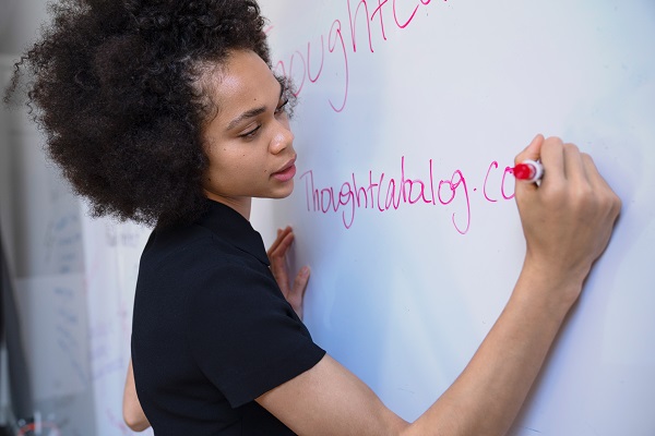 Woman solving problems and writing on the whiteboard