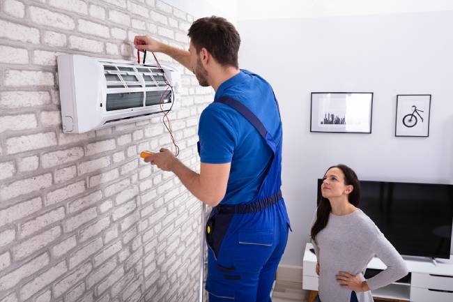 Repair man fixing an air conditioner