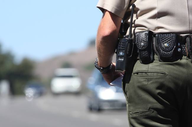 A police officer standing by traffic on a city street