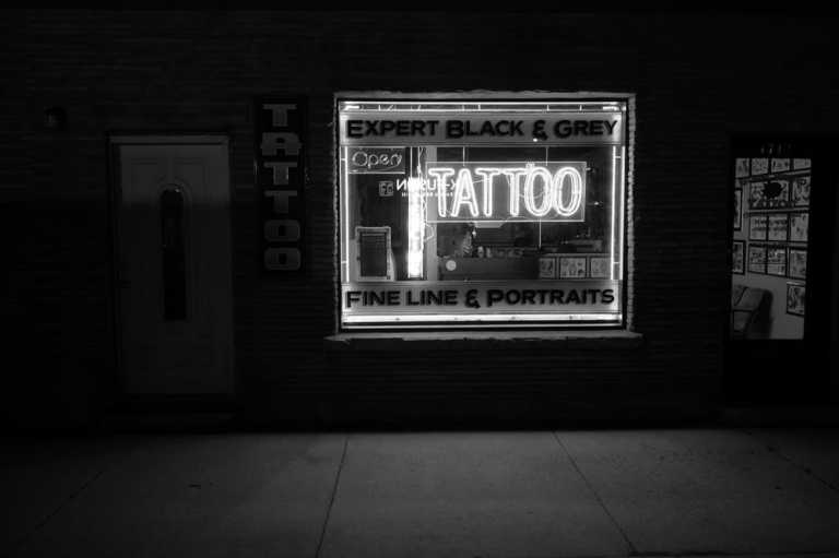 Grayscale photo of a tattoo shop signage.