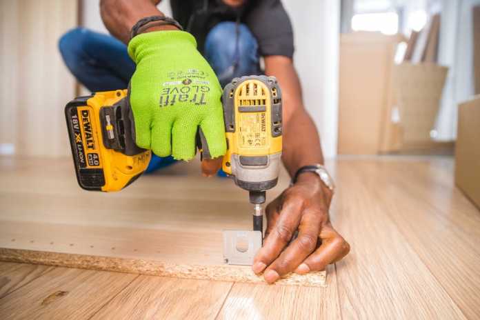 Best Handyman in Newcastle Handyman using Dewalt Cordless Impact Driver on brown board.