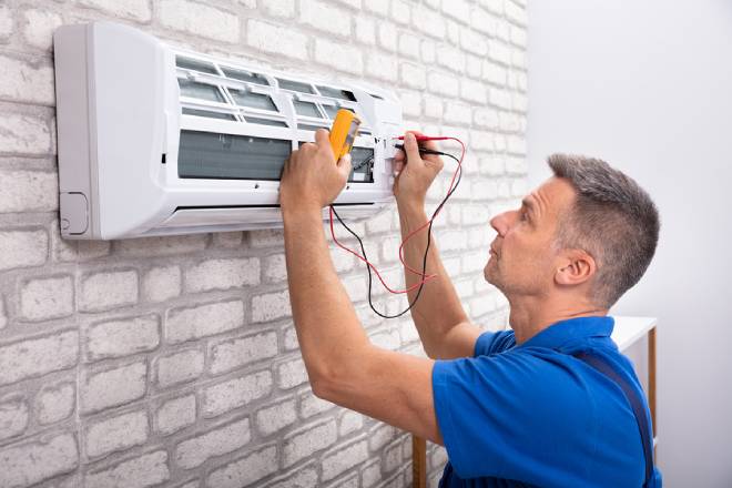 Male Electrician Checking Air Conditioner