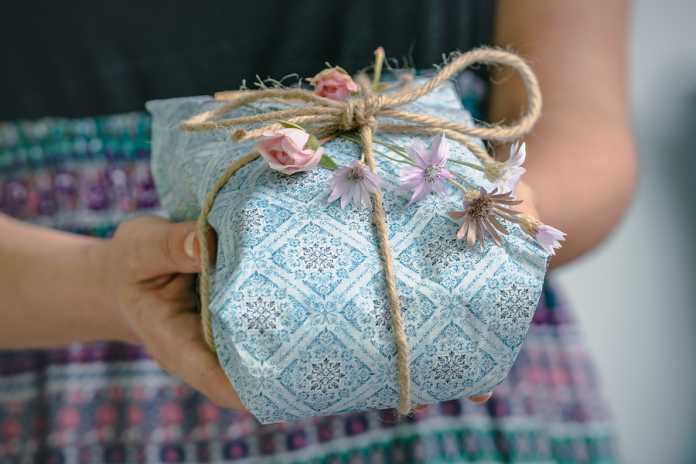 Hands Holding Gift Box With Flowers. Gift Present. Close Up Of H Buying that impossible gift what to select when you reach a present dead-end