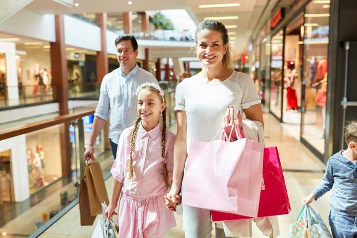 Happy parents and kids shopping in shopping arcade Shopping tips to help you save
