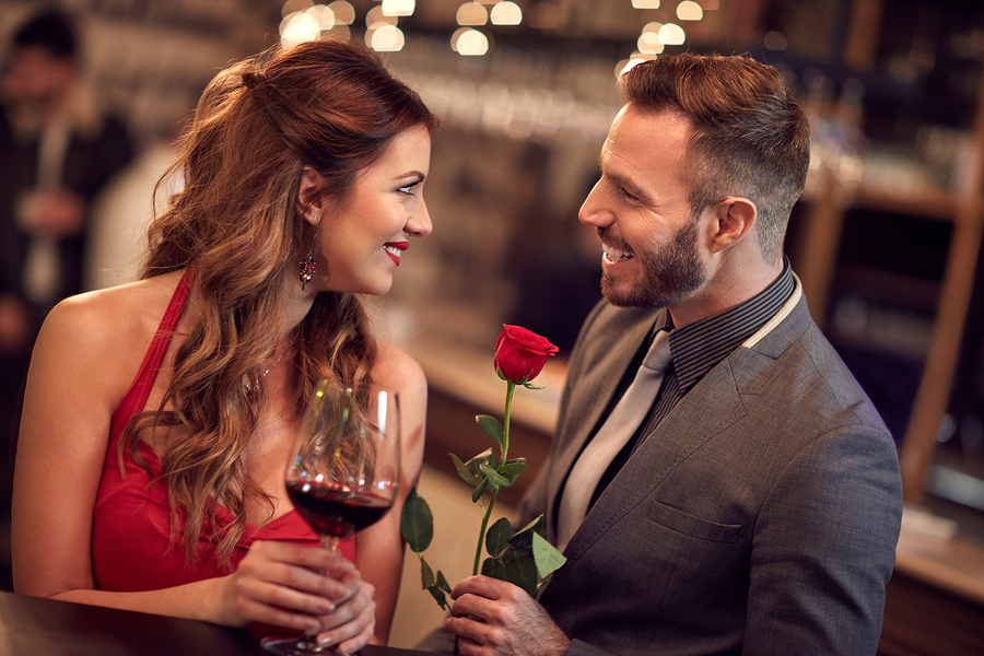 Handsome man giving rose to attractive lady