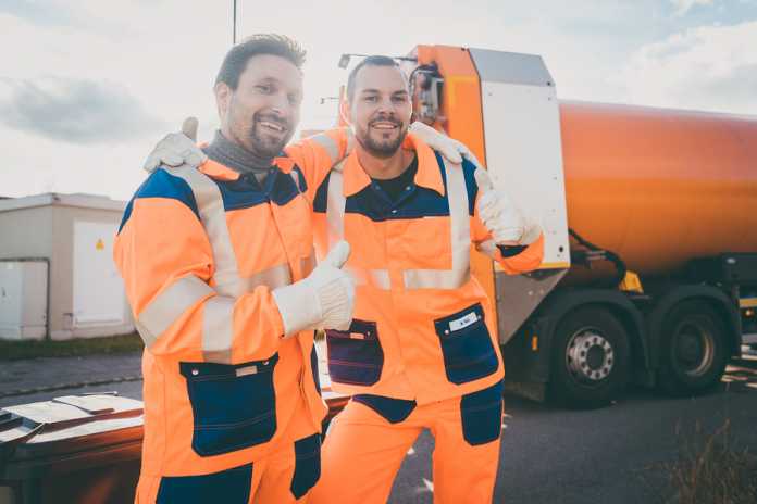 Garbage removal workers giving a thumbs-up in front of disposal Underrated benefits for residents hiring experienced rubbish removal services
