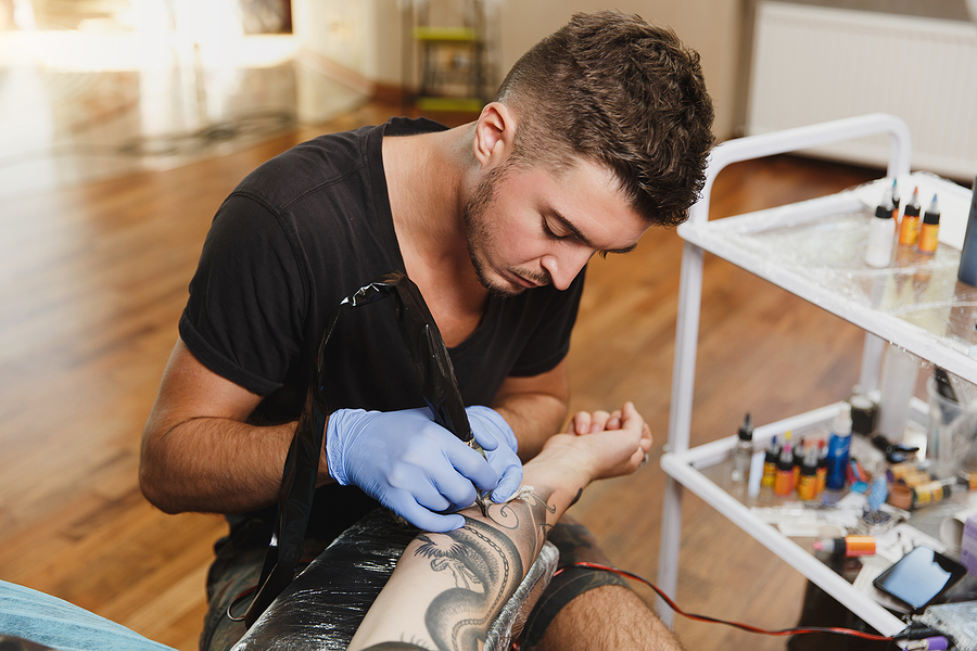 tattoo artists making a tattoo