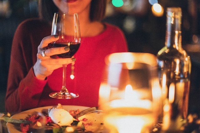 A woman with a plate of food and a glass of wine dining on her Australian cruise in 2022.